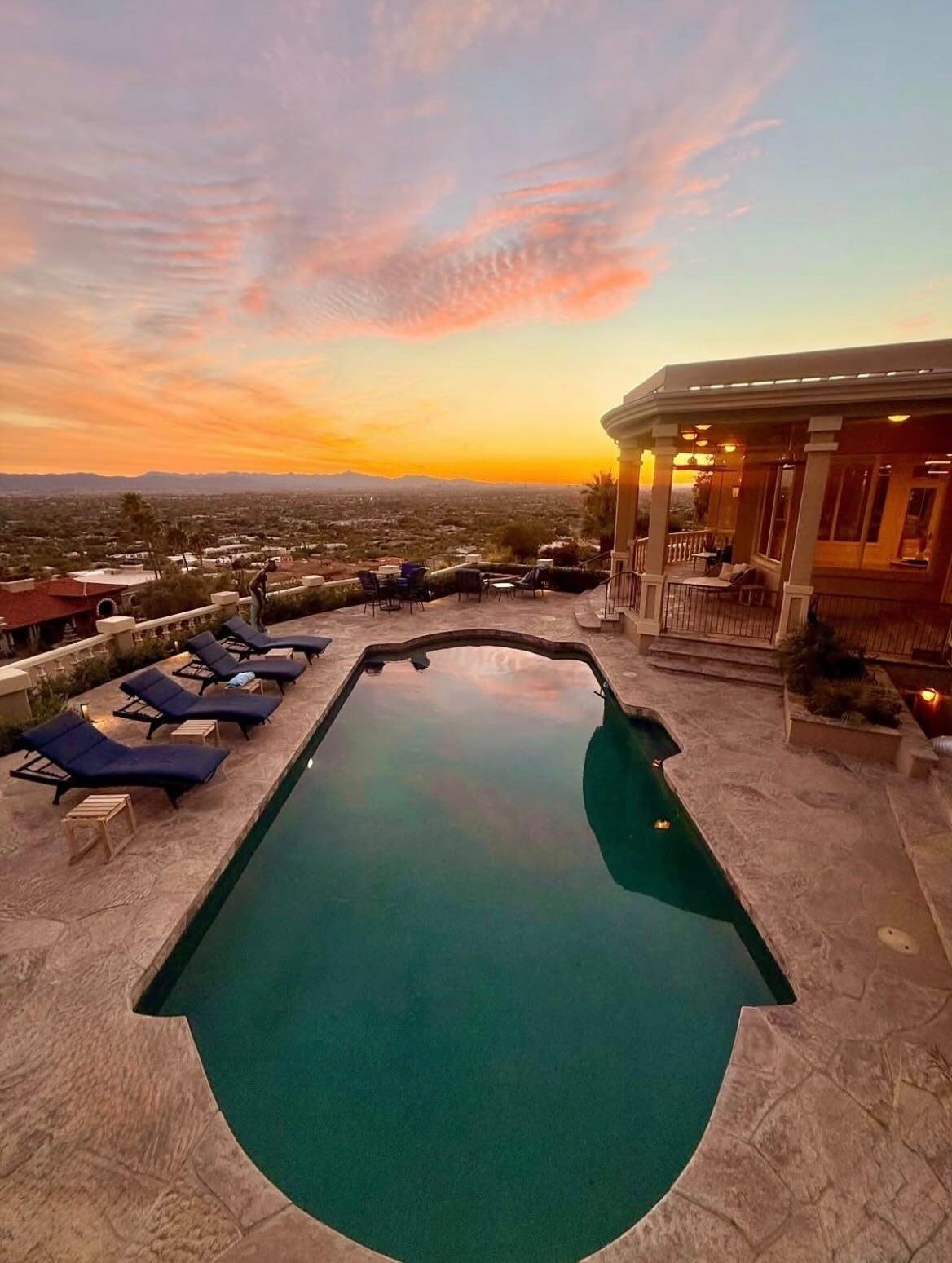 A desert resort pool and loungers beneath a rose-and-gold Scottsdale sunset sky