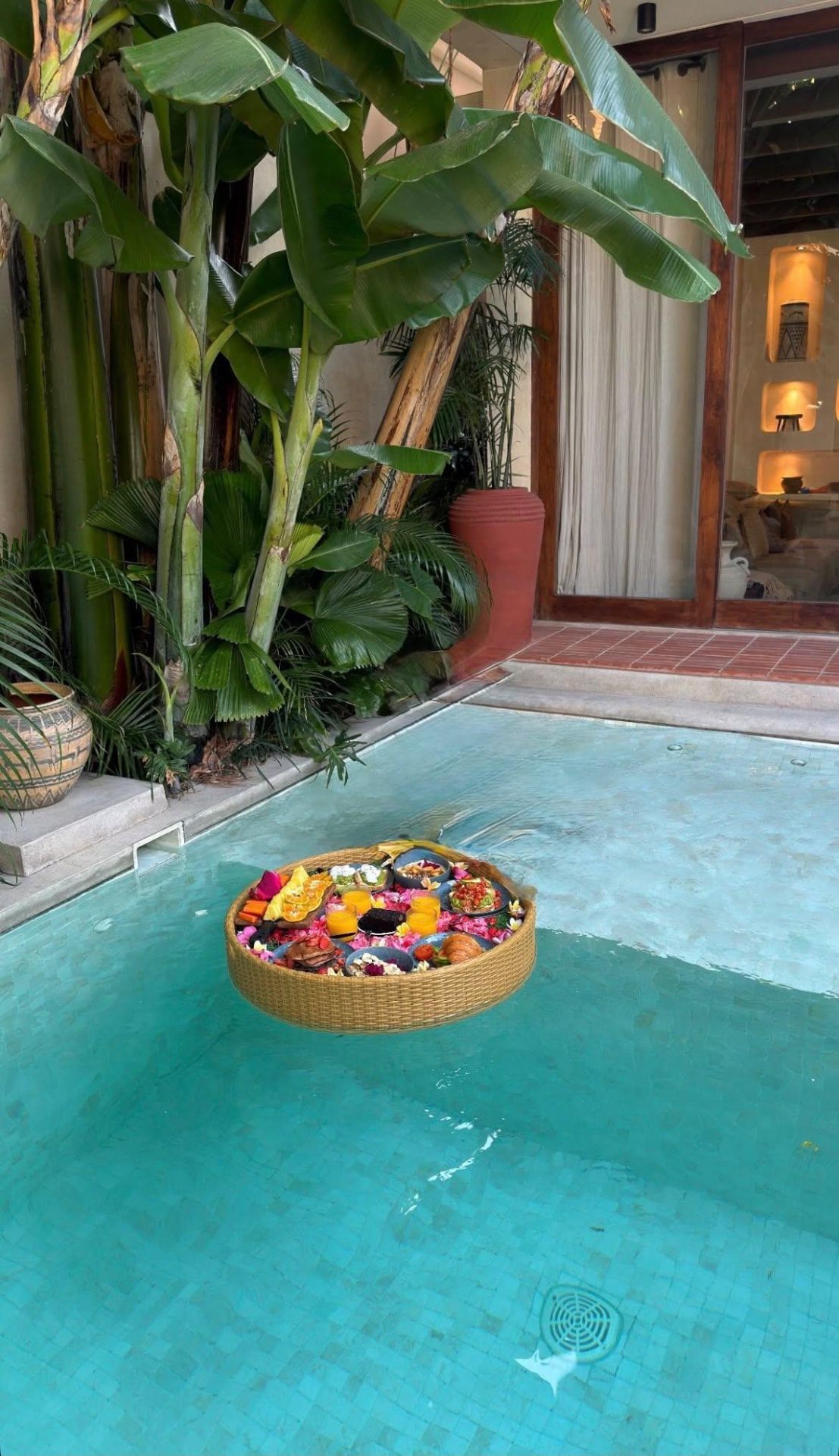 A private tropical plunge pool with a floating breakfast tray and lush greenery